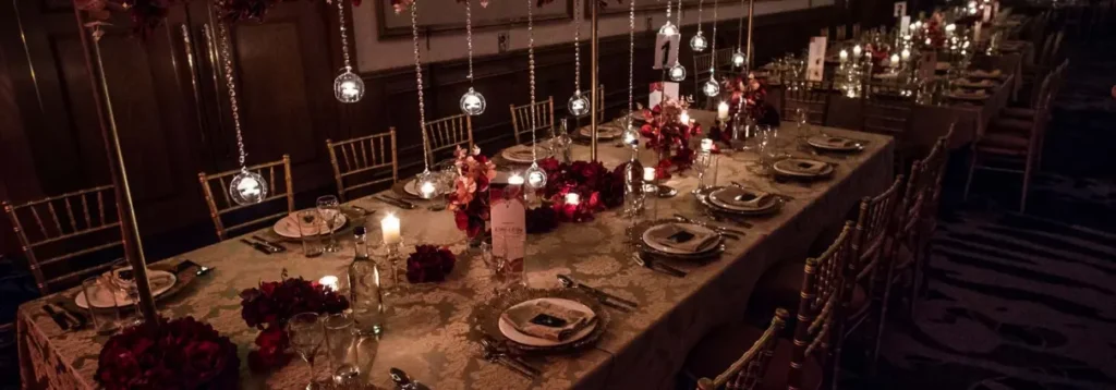 Elegant long restaurant table set with candles, flowers and place settings for a client meeting