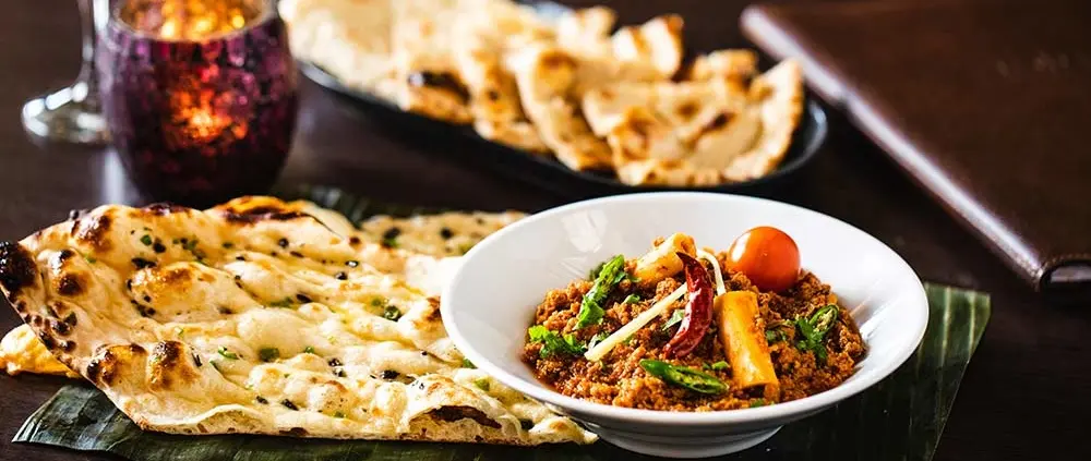 Indian curry with charred naan bread served in a restaurant