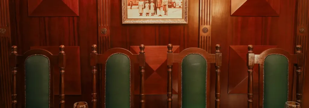 Wooden dining chairs with green upholstery in a warm Indian restaurant interior
